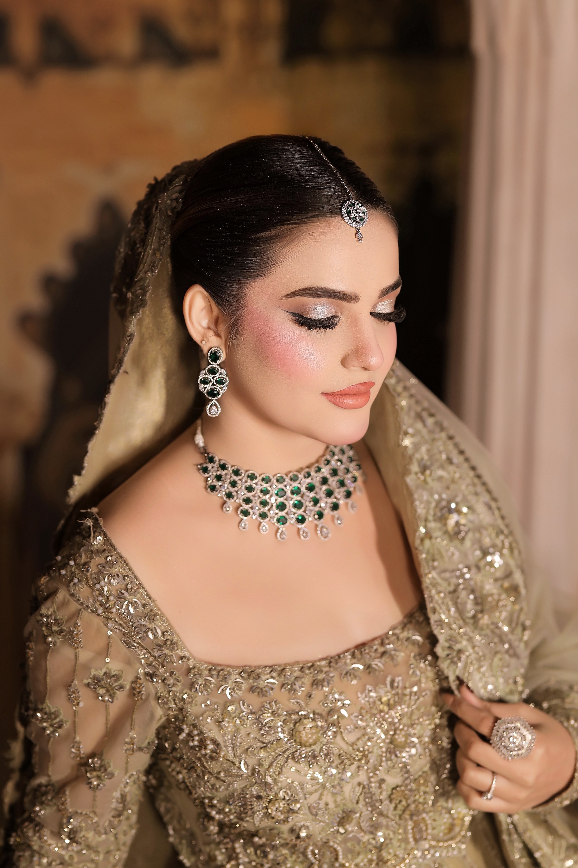 Bride with emerald jewelry and softly defined bridal makeup