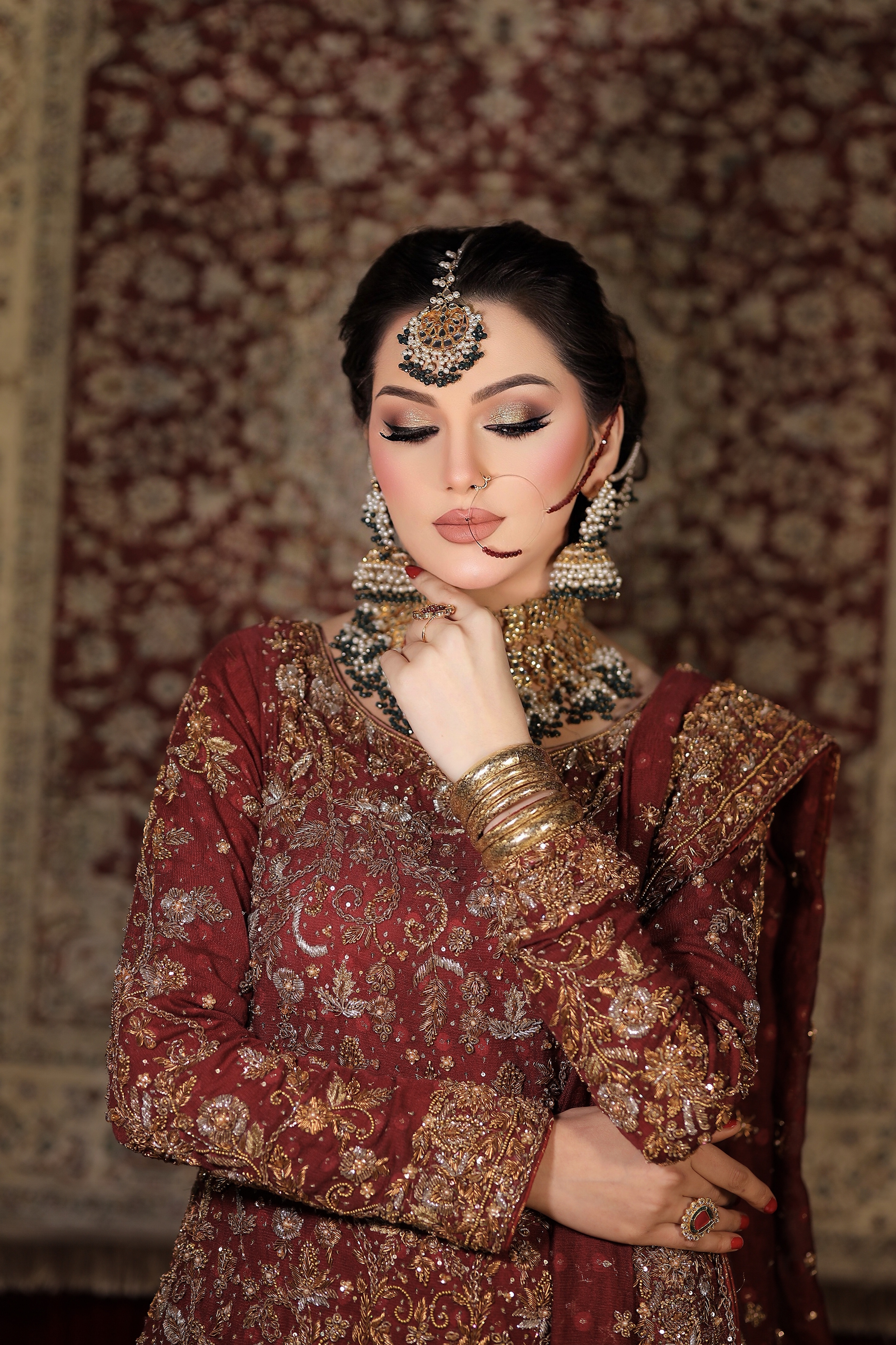South Asian bride with a luminous complexion and rich maroon bridal styling